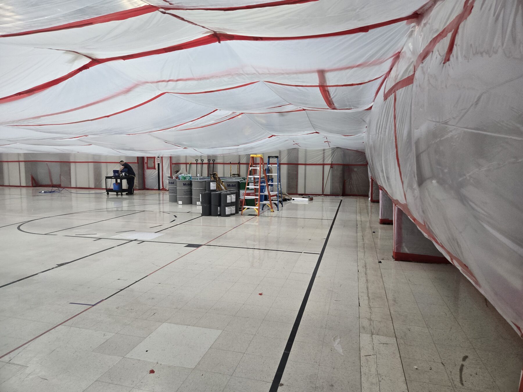 Full-gym negative-pressure containment built inside a school before asbestos abatement